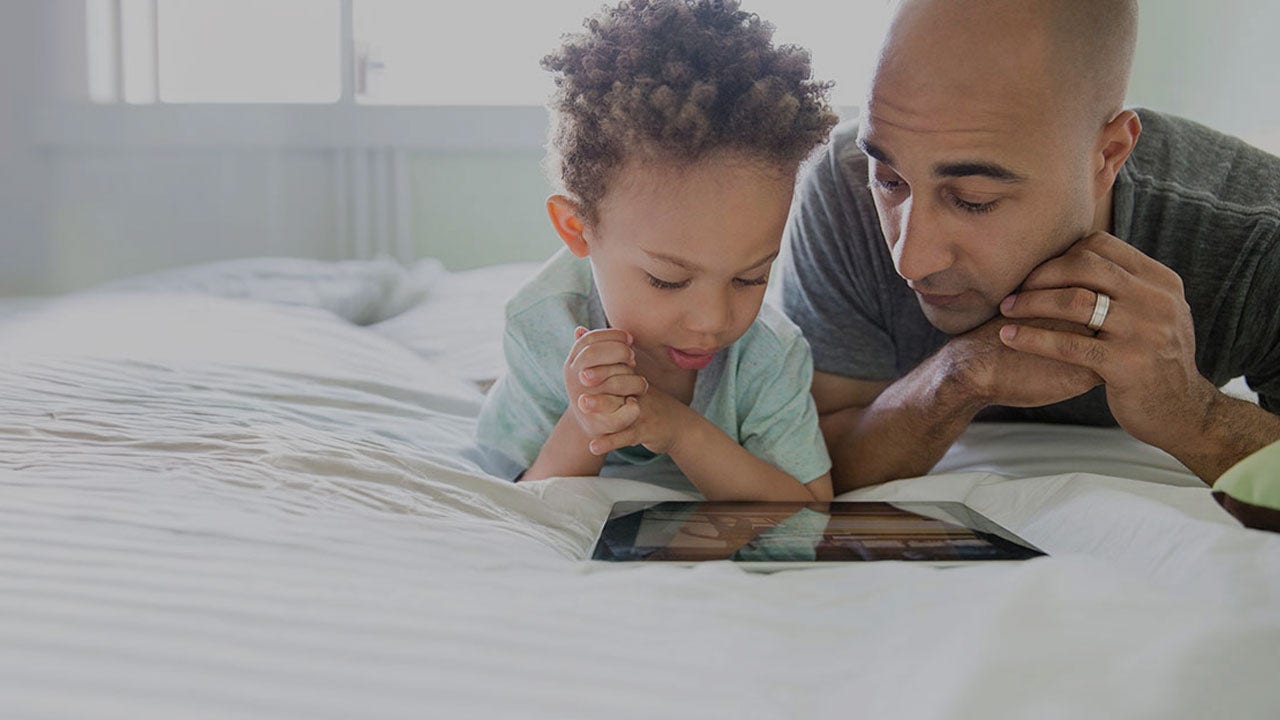 Father and son checking a tablet.