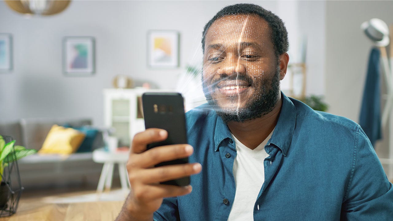 Smiling man holding a phone.